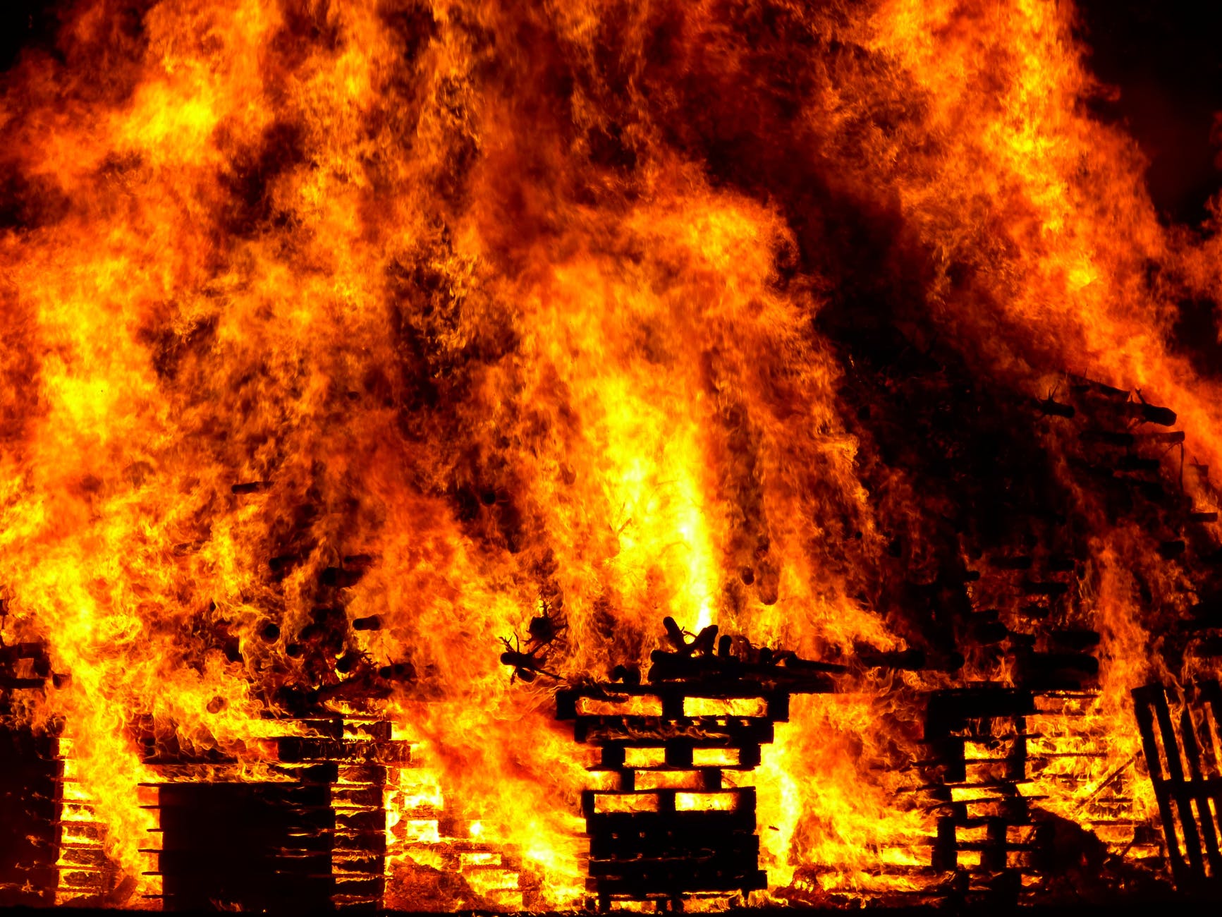 image of a structure on fire, engulfed in orange, yellow, and red flames